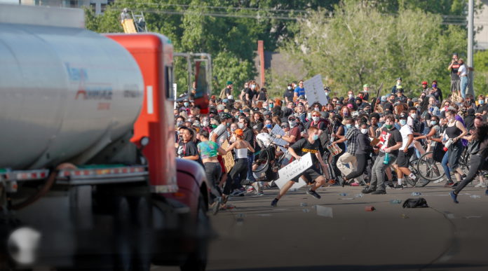 Protesters demonstrating against the death of George Floyd flee as a truck drives through the crowd on a Minneapolis highway.